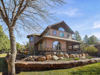 This stunning property boasts a beautiful exterior with a multi-level design and a charming stone facade.