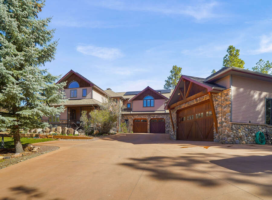 This stunning property boasts a luxurious design with a spacious driveway leading to a multi-car garage.