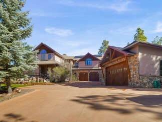 This stunning property boasts a luxurious design with a spacious driveway leading to a multi-car garage.