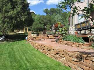 Discover the charm of this stunning property, featuring a beautifully landscaped yard and a meticulously crafted stone retaining wall.