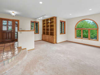 Step into this inviting living space featuring a grand entryway with tiled flooring and a charming wooden door.