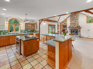 Experience the warmth of this inviting kitchen, featuring custom wood cabinetry and a large island perfect for entertaining.
