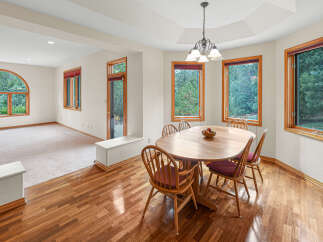 This inviting dining area features a large oval wooden table with four matching chairs, perfect for family meals.
