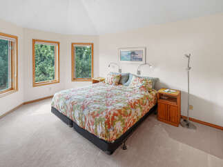 This charming bedroom features a large, comfortable bed adorned with a vibrant floral comforter, creating a cozy and inviting atmosphere.