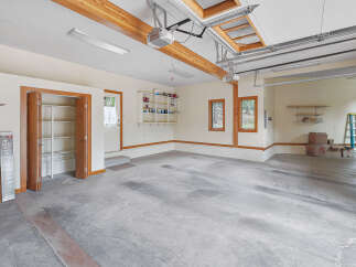 Discover ample storage and functionality in this spacious garage, featuring built-in shelving and convenient closet space.