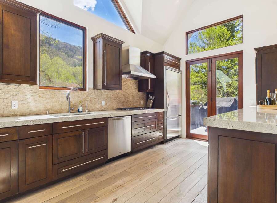 This stunning kitchen boasts a modern design with sleek, dark wood cabinetry and stainless steel appliances.