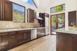 This stunning kitchen boasts a modern design with sleek, dark wood cabinetry and stainless steel appliances.