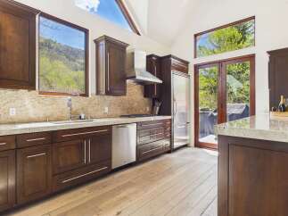 This stunning kitchen boasts a modern design with sleek, dark wood cabinetry and stainless steel appliances.