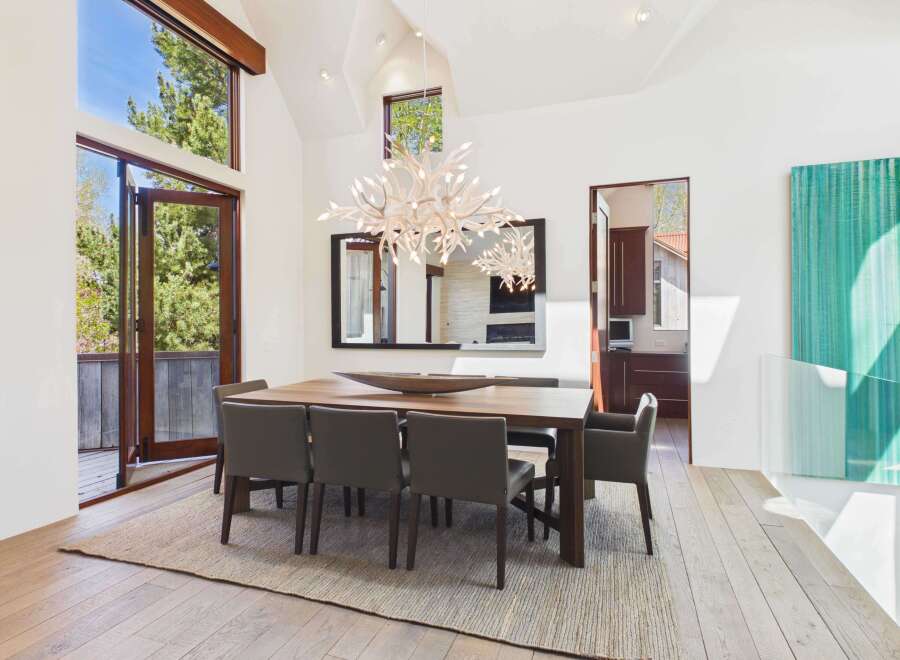 This stunning dining room showcases a modern design with high ceilings and ample natural light.