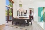 This stunning dining room showcases a modern design with high ceilings and ample natural light.
