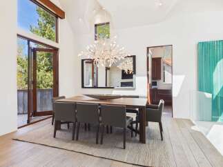 This stunning dining room showcases a modern design with high ceilings and ample natural light.