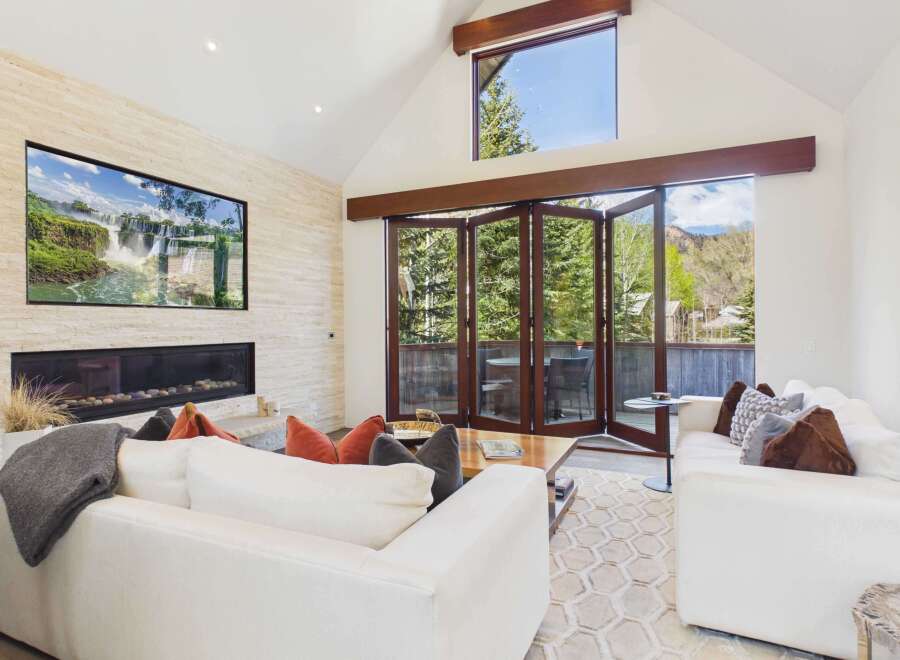 Experience luxury living in this stunning property featuring a modern fireplace and a large screen TV.