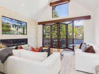 Experience luxury living in this stunning property featuring a modern fireplace and a large screen TV.