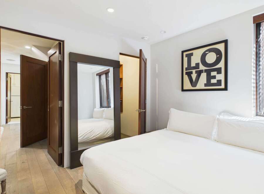 This stunning bedroom boasts a modern design with a large mirror and a cozy bed.
