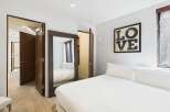 This stunning bedroom boasts a modern design with a large mirror and a cozy bed.