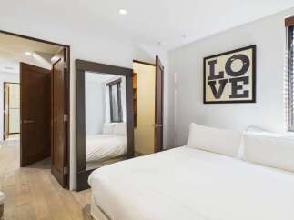 This stunning bedroom boasts a modern design with a large mirror and a cozy bed.