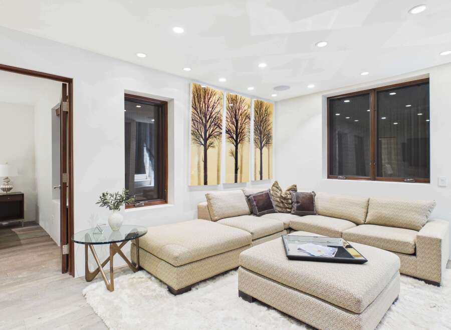 This stunning living room boasts a modern design with a comfortable sectional sofa and a stylish ottoman.