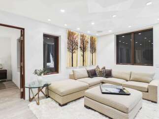 This stunning living room boasts a modern design with a comfortable sectional sofa and a stylish ottoman.