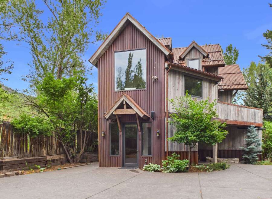 Discover this unique rustic home featuring corrugated metal siding and a distinctive architectural style.