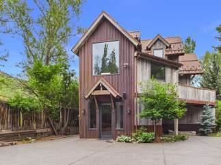 Discover this unique rustic home featuring corrugated metal siding and a distinctive architectural style.
