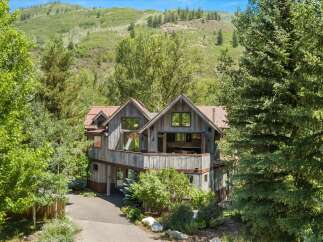 Nestled amidst lush greenery and rolling hills, this rustic mountain home offers a serene escape.