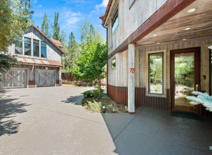Experience rustic charm with this stunning property featuring a weathered wood exterior and corrugated metal accents.