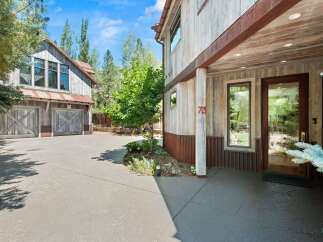 Experience rustic charm with this stunning property featuring a weathered wood exterior and corrugated metal accents.