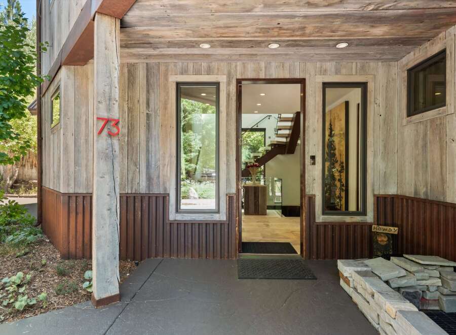 Experience rustic charm with this unique home featuring a weathered wood exterior and corrugated metal accents.