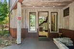 Experience rustic charm with this unique home featuring a weathered wood exterior and corrugated metal accents.