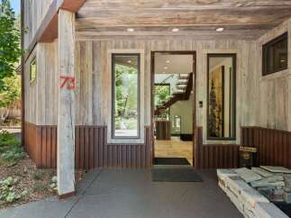 Experience rustic charm with this unique home featuring a weathered wood exterior and corrugated metal accents.