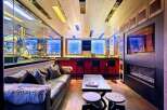 Experience ultimate luxury in this custom-designed entertainment space, featuring a stunning motorcycle display, a fully equipped bar with plush seating, and a modern fireplace.
