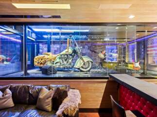 Experience the ultimate man cave, featuring a stunning display of a classic motorcycle and musical instruments behind glass.