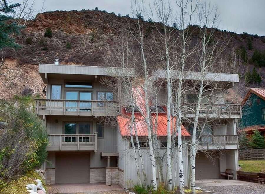 This stunning property boasts a modern design with multiple levels and balconies, offering breathtaking views of the surrounding natural landscape.