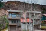 This stunning property boasts a modern design with multiple levels and balconies, offering breathtaking views of the surrounding natural landscape.