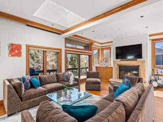 Experience luxury living in this stunning property, featuring a spacious living room with a cozy fireplace and a modern entertainment setup.