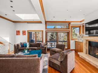 Experience luxury living in this stunning property featuring a spacious living room with a cozy fireplace and ample seating.