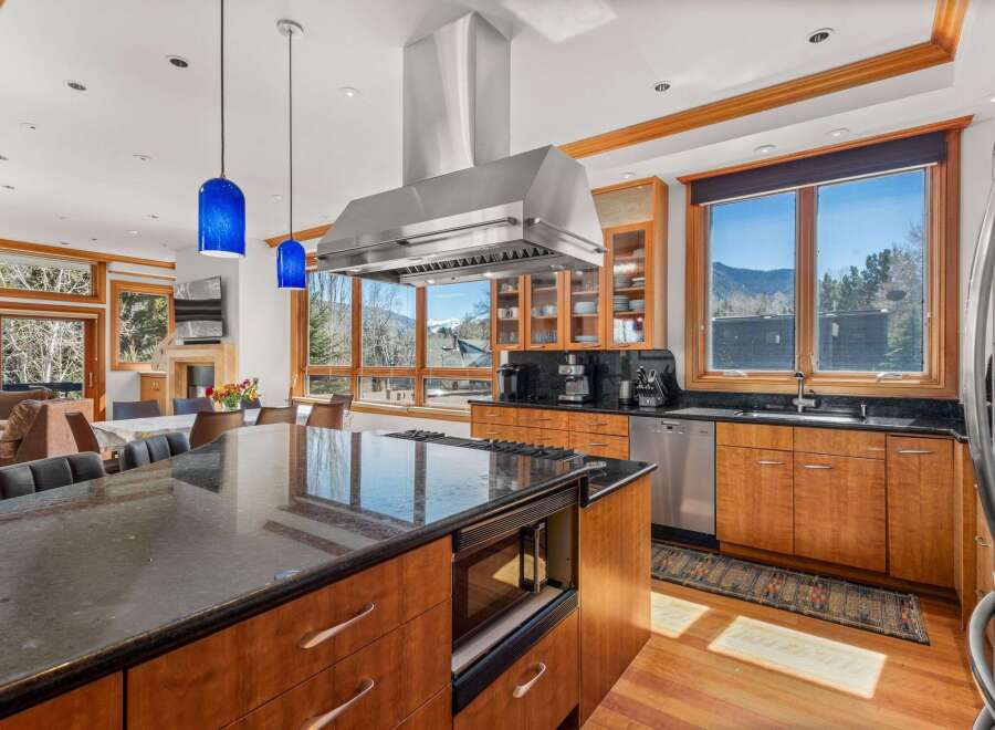 This stunning kitchen boasts high-end appliances, including a stainless steel range hood and a built-in microwave.