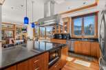 This stunning kitchen boasts high-end appliances, including a stainless steel range hood and a built-in microwave.