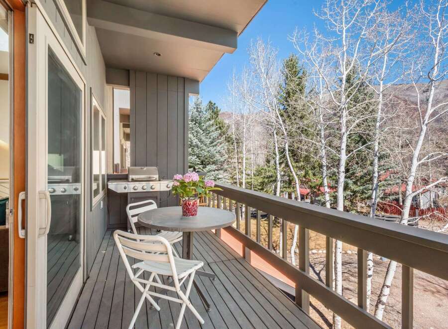 Enjoy breathtaking views from this stunning balcony! This outdoor space features a grill, perfect for entertaining, and a cozy table with chairs.