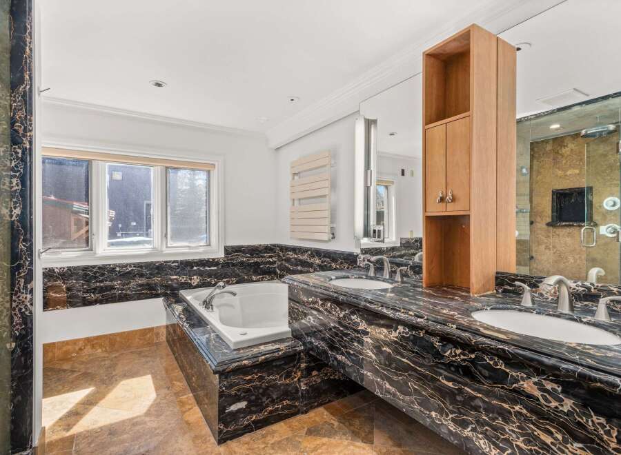 Indulge in luxury within this stunning bathroom, featuring exquisite black marble countertops and a sleek, modern design.