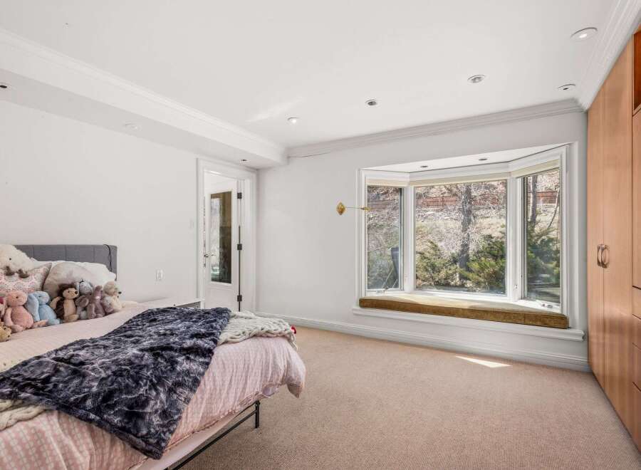 This inviting bedroom features a cozy atmosphere with a plush bed and a stylish window seat.