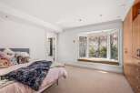 This inviting bedroom features a cozy atmosphere with a plush bed and a stylish window seat.