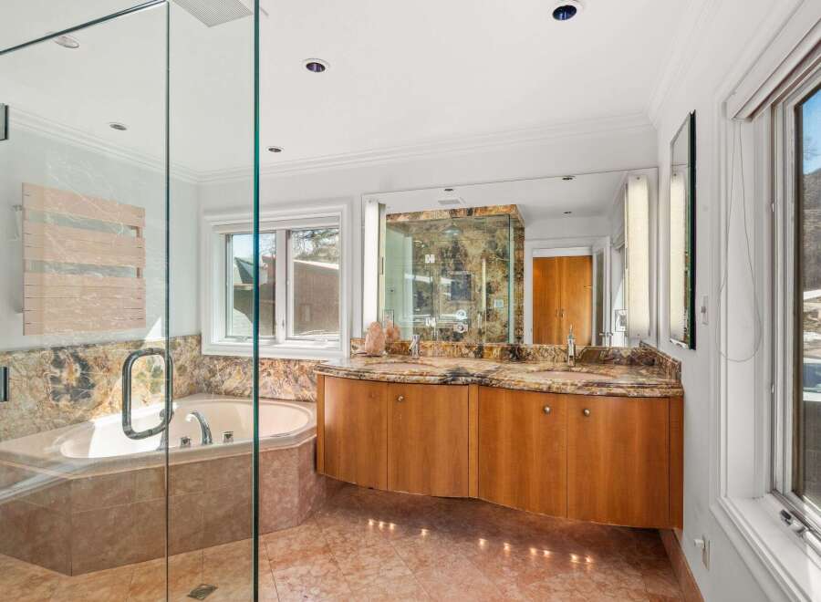 Step into luxury with this stunning bathroom featuring a spacious walk-in shower and a relaxing soaking tub.