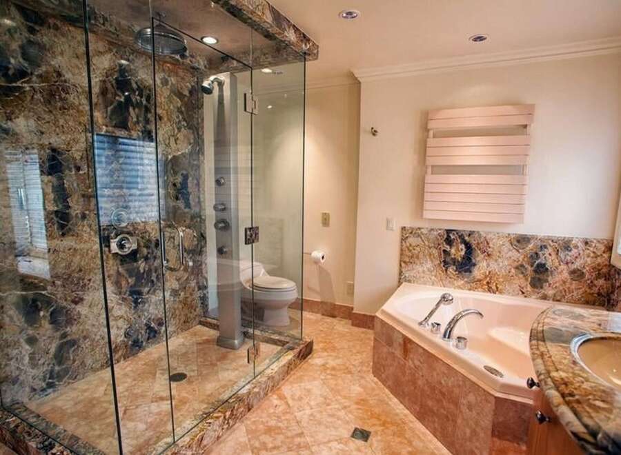 Step into luxury with this stunning bathroom featuring a spacious glass-enclosed shower and a relaxing soaking tub.