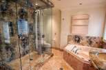 Step into luxury with this stunning bathroom featuring a spacious glass-enclosed shower and a relaxing soaking tub.
