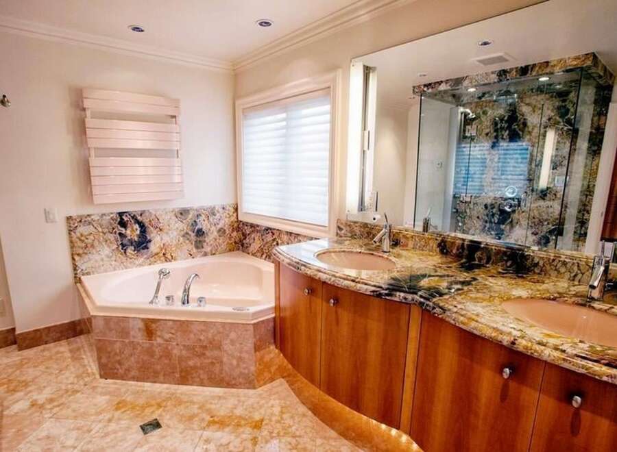Step into luxury with this stunning bathroom! Featuring a beautiful bathtub, a curved vanity with dual sinks, and a gorgeous marble countertop, this space is designed for relaxation and style.