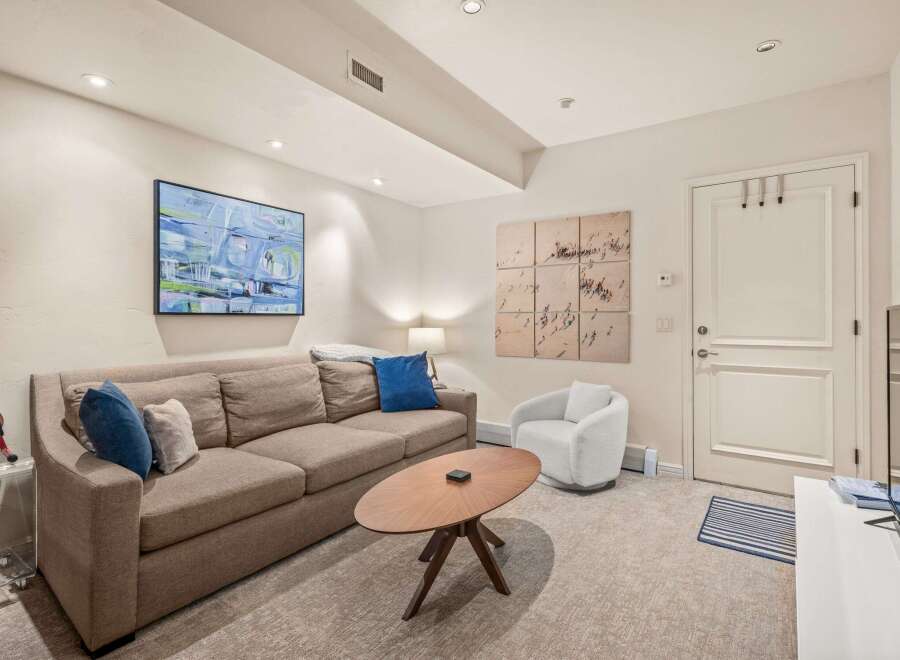 Step into this inviting living space, featuring a cozy sofa adorned with plush pillows, perfect for relaxation.