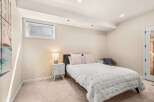 This cozy bedroom offers a serene retreat with its neutral color palette and ample natural light.