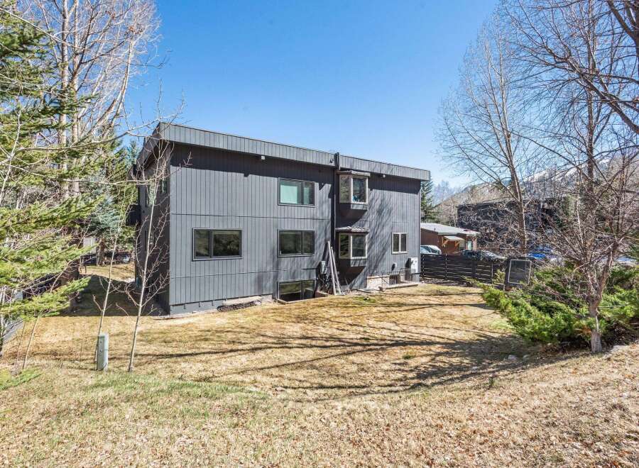 Discover modern living in this stunning property! This home boasts a sleek, contemporary design with a dark exterior and multiple windows.