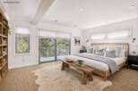 This stunning bedroom offers a serene retreat with its bright, airy design and natural light.